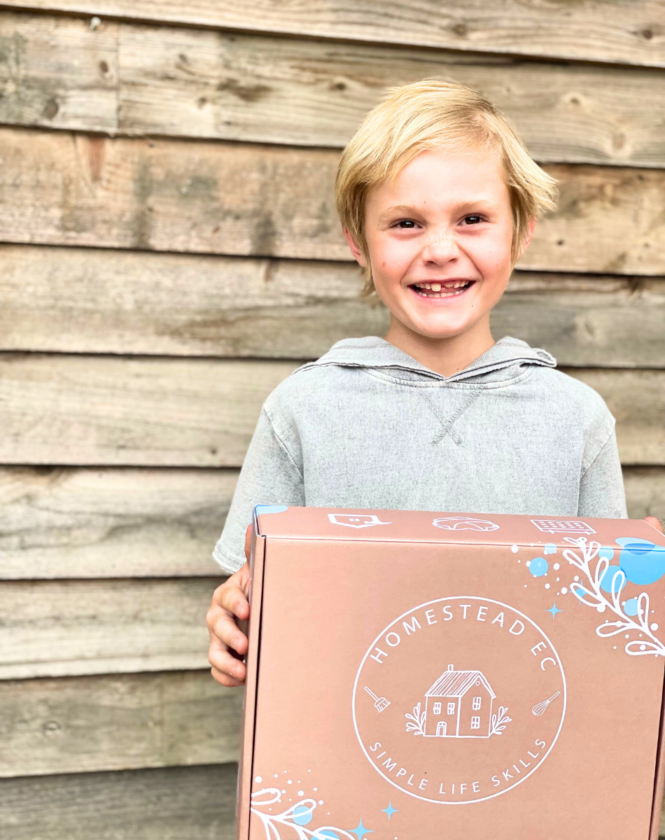 little boy holding the subscription box smiling