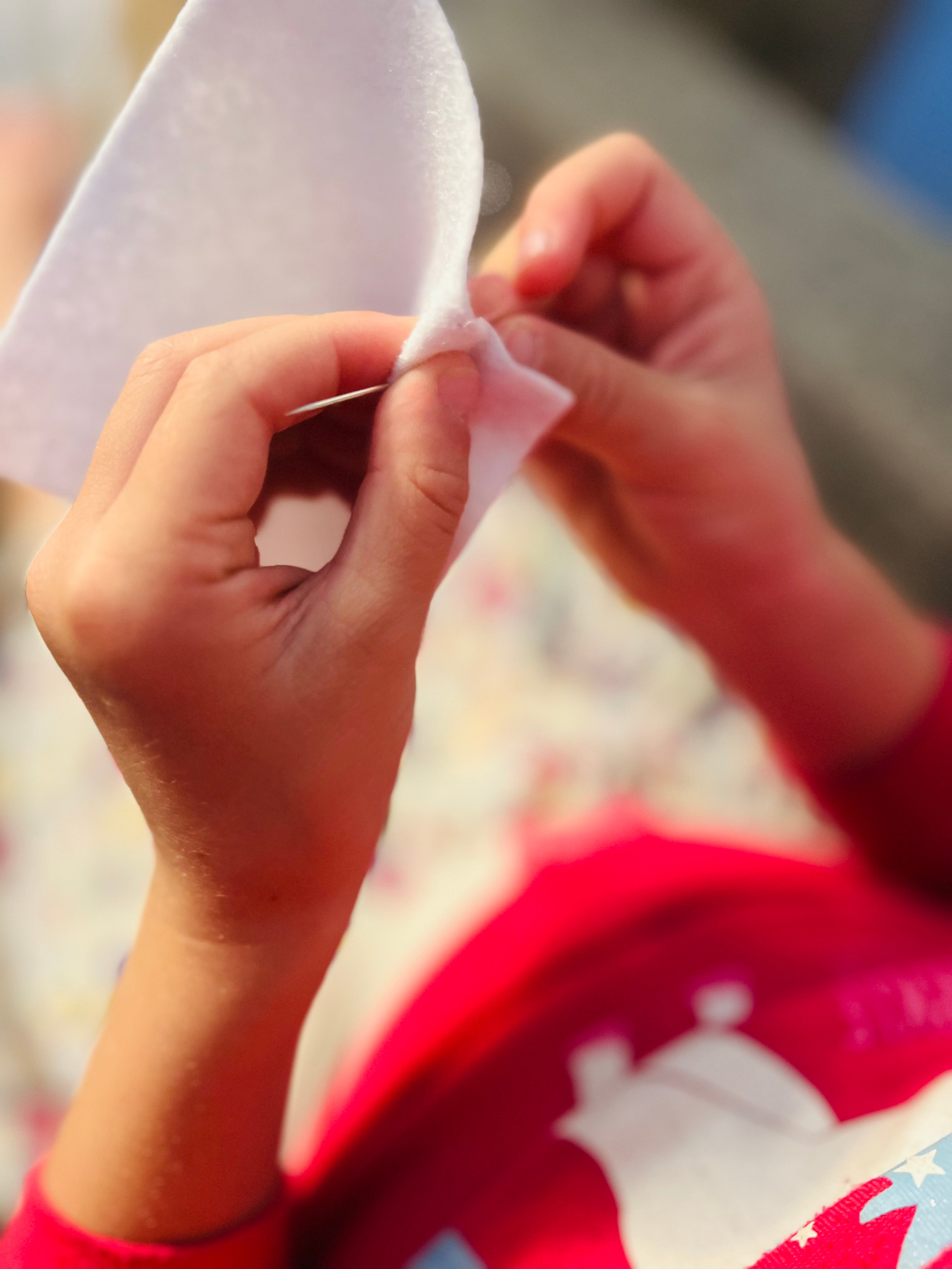 little girl learning to sew